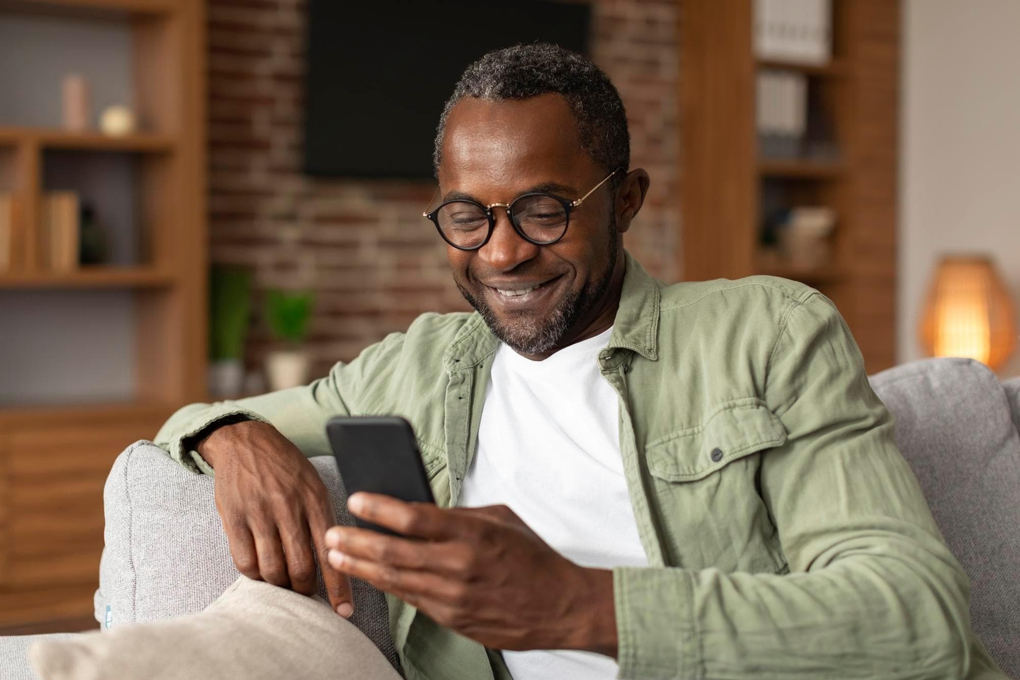 Smiling man reviewing credit report on device